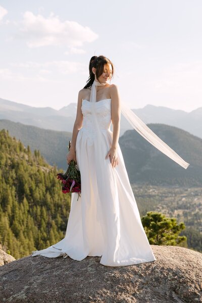 Bride standing on mountaintop during Colorado elopement with scenic views — Colorado elopement photographer
