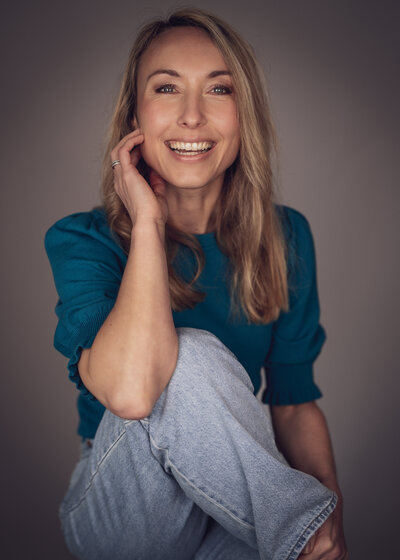 Blond model lachend naar camera.