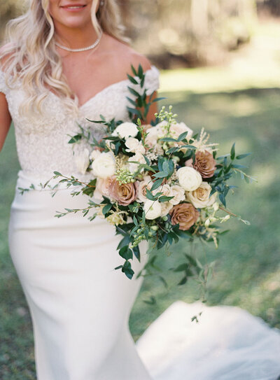 Neutral bridal bouquet with billowing greenery and cafe latte roses