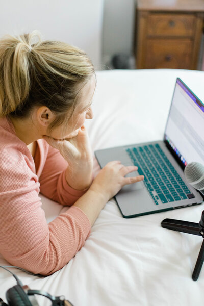 Showit website designer on her computer in front of bulletin board