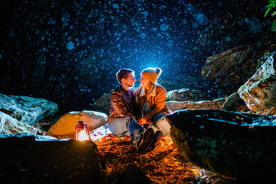 An engaged couple poses for portraits at Dark Hollow Falls in Shenandoah National Park, beautifully illuminated with flash from behind, captured by Nathan Sottung Photography