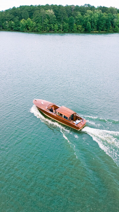 Classic wood boat engagement couple on lake oconee ride across teal waters