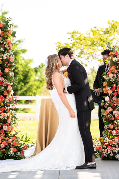 Bride and groom kissing at the altar