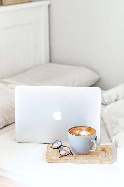 Image of a laptop with coffee and glasses on a couch