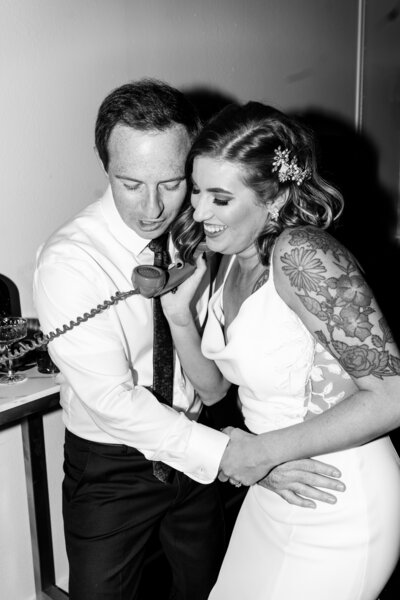 bride and groom hold telephone