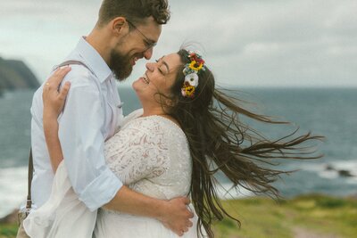 bride and groom laugh by the ocean during their Newfoundland elopement