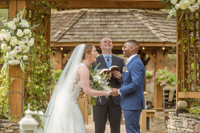 A bride and groom laugh as their officiant speaking during their wedding ceremony in Nashville, Tennesse.