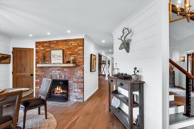 A cozy living area with a brick fireplace, designed by Signature Renovating to create a warm and inviting atmosphere.