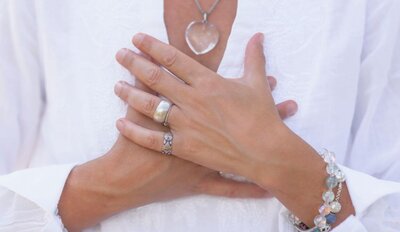 Woman's hands in prayer over heart