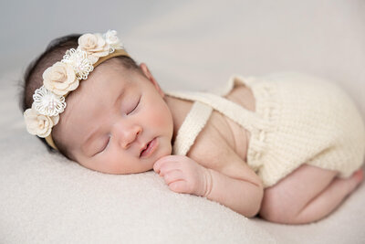 Newborn photography, image of newborn asleep with floral headband, captured by LV Photo Haus