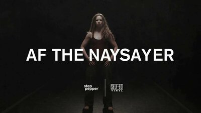 Woman standing and looking into the camera with her hands on her hips. In front of her, text reads AF The Naysayer