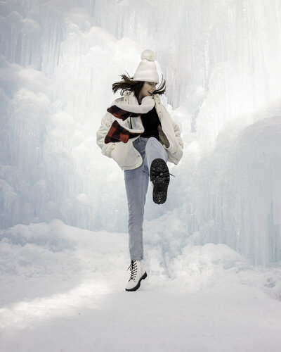 Woman jumping in the air at the New Hampshire ice castles.