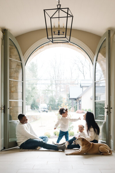 Parents snuggling on lower level of tree house while three kids play above - Northern Virginia family photographer