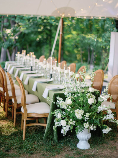 green wedding table with brown chairs and flowers