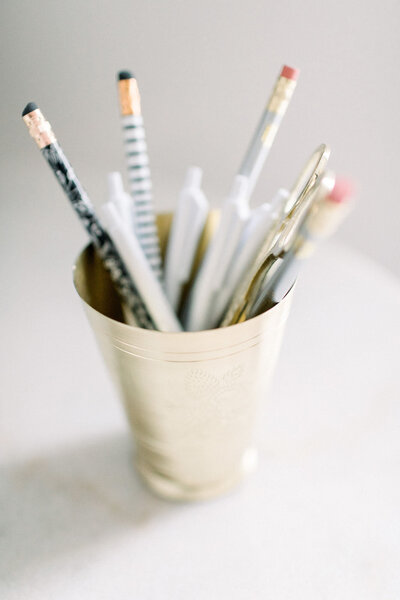 Stock image of NH Maternity Photographer Kathleen Jablonski's desk with pencils and pens in a gold cup