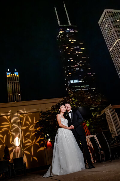 Bride and groom on the patio in front of the John Hancock building at The Peninsula Hotel in Chicago