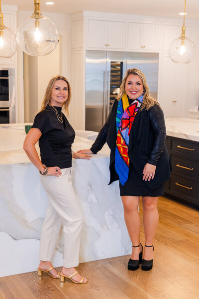 women realtor team standing in kitchen in front of counter top during brand photoshoot Laure Photography