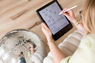 sketching logo ideas on ipad next to big disco ball