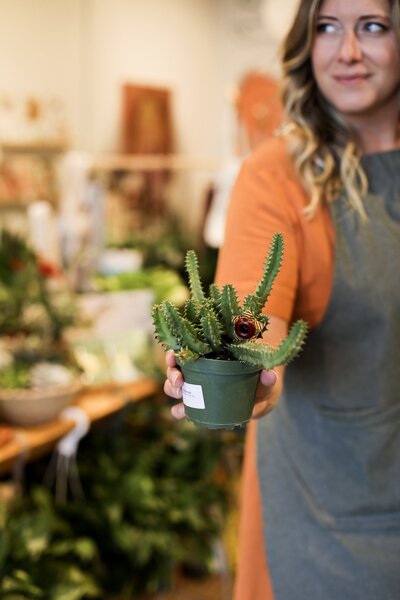 lady holding small indoor plant
