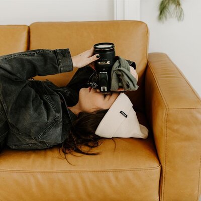 woman laying on a couch and pointing camera
