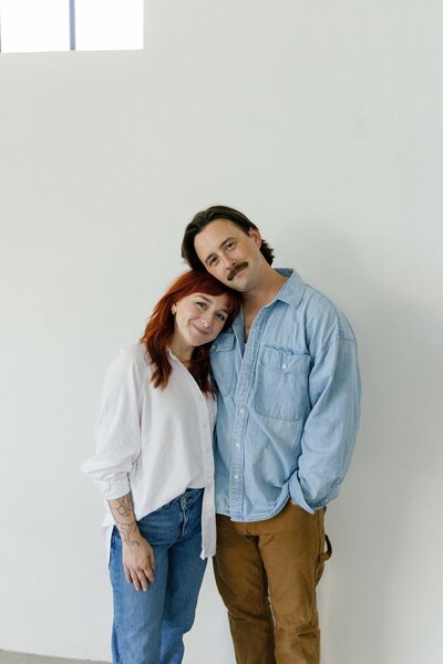 Couple hugs and smiles at camera in photo studio