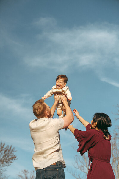 dad lifting baby in the air during an outdoor family session