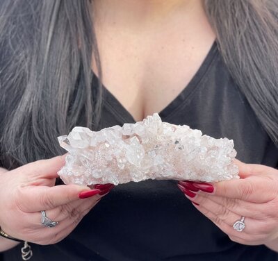 woman holding big pink crystals outside