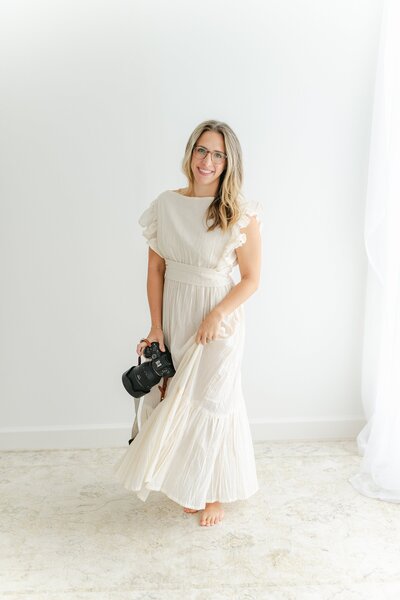woman in white flowy dress holding her camera