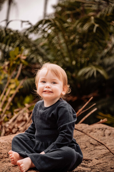 Baby girl sitting in a park clapping her hands - Townsville Milestone Photography by Jamie Simmons