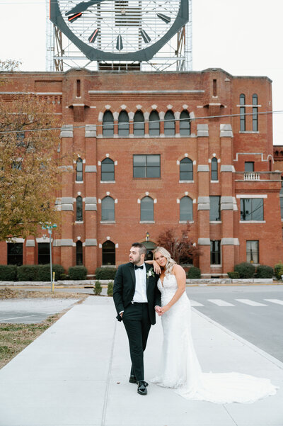 Bride and groom posing in front of building