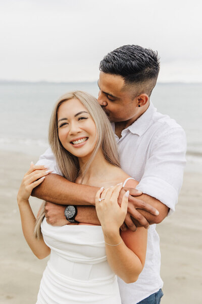 newly engaged couple hugging on beach