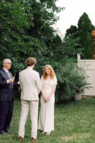 Peyton Curry and Jon exchange vows during their intimate backyard wedding ceremony in Richmond, Virginia, captured by a film-style photographer specializing in candid wedding photography.