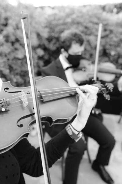 Black and white photo of bride's mother zipping up her dress