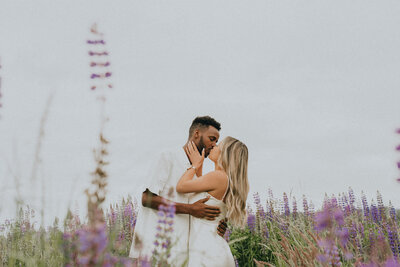couple kissing in a lupine field