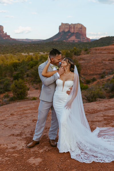 Wedding couple kisses in Sedona’s red rock embrace for Arizona shoot.
