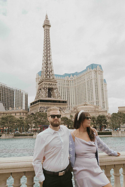 Couple leans on wall together in front of las vegas Eiffel tower