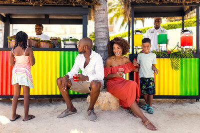 couple sitting at a beach bar with their kid at a resort