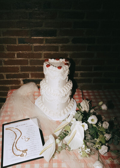 Wedding cake, bouquet and menu at a Boston wedding reception. Photo by Rhode Tripper Photography