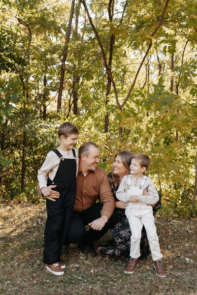 Man and Woman kneeling next to eachother smiling with kids on the side of them
