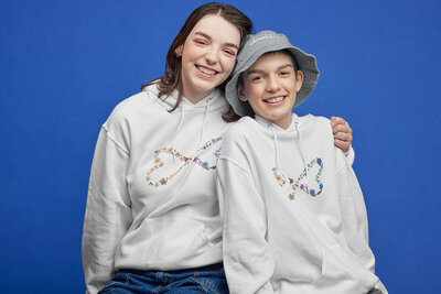 two teenage girls posing together while wearing fundraiser merch