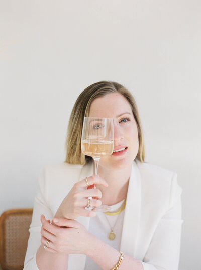 Woman holding a wine glass in front of her face