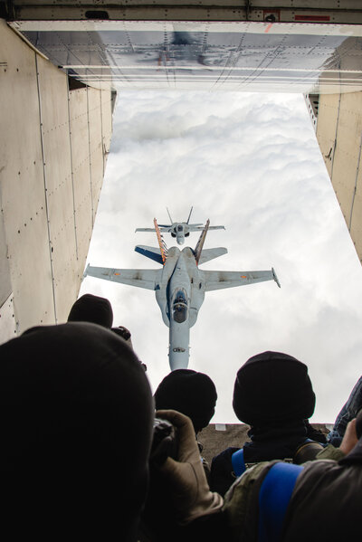 Das Bild zeigt Fotografen in der Pink Skyvan, die einen Jet fotografieren, der in Formation fliegt