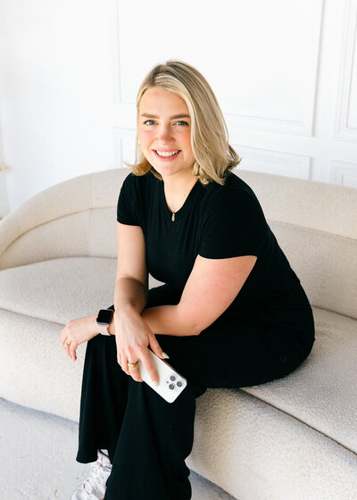 A woman named Tessa, a content creator from Ohio, sits on a couch holding an iPhone.