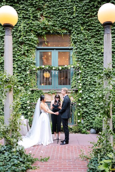 Wedding ceremony in outdoor courtyard wrapped in Ivy.