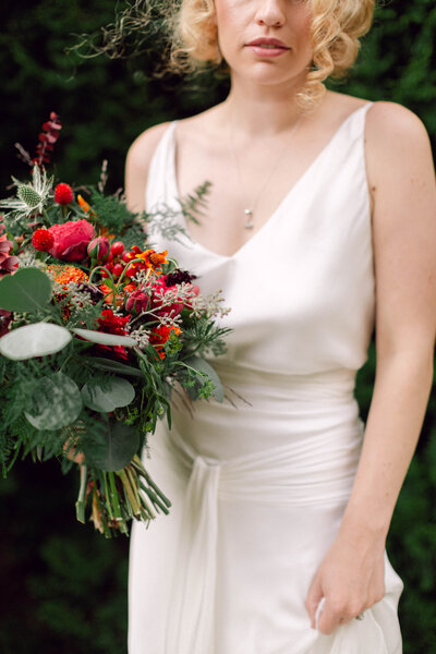 Bride gracefully holding her bouquet and wedding dress train during a photo session in New York City.