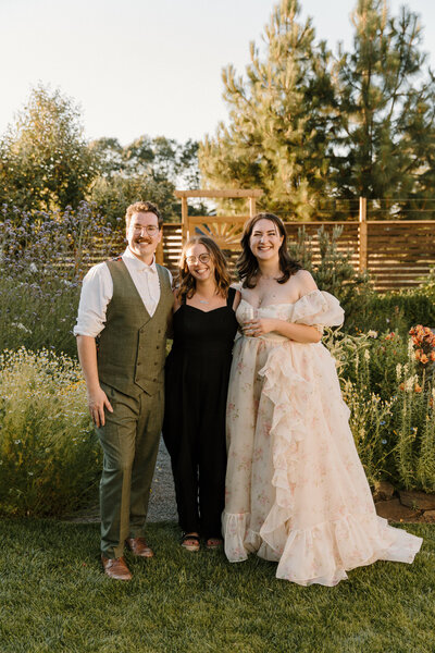Rachel poses with two of her clients on their wedding day