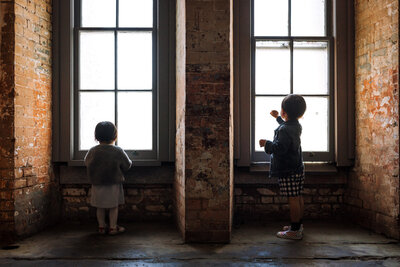 two kids standing in front of two windows at Fort Point in San Francisco