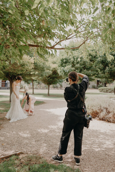 A behind the scene photo of Phoebe Dunn the photographer photographing a bride on her wedding day.