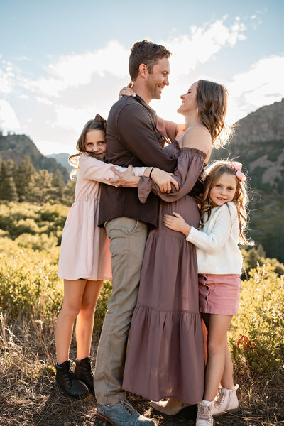 Family holding hands walking through tall grass with mountains
