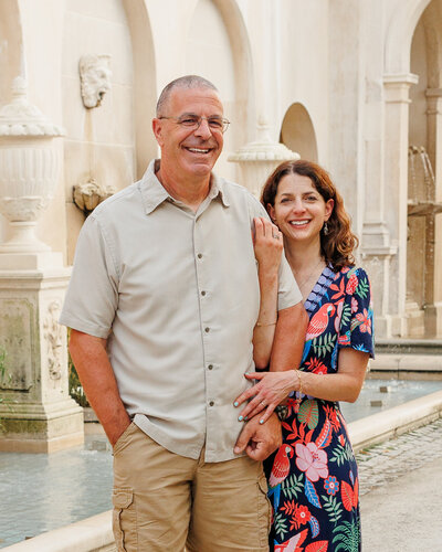 Couple posing in front of a beautiful stone water fountain